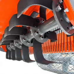 Vue par dessous du rotor à lames, de la grille de séparation et du rouleau de l’enfouisseur de pierres
